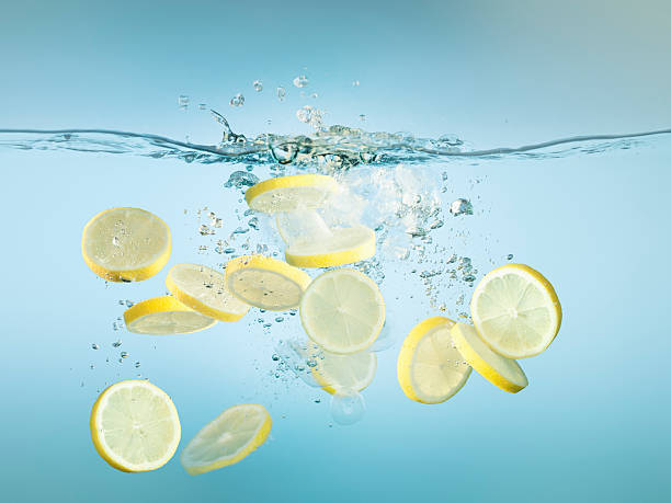 Sliced lemons splashing in water  lemon fruit stock pictures, royalty-free photos & images