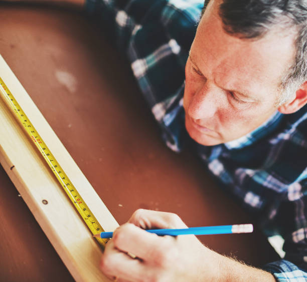 istock Mature man measuring wood for DIY project 979726388