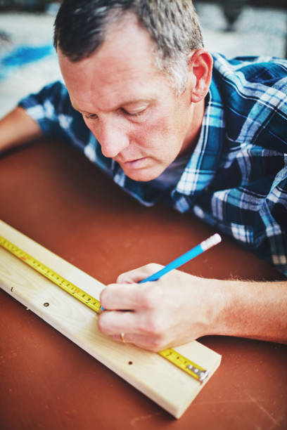 Mature man measuring wood for DIY project