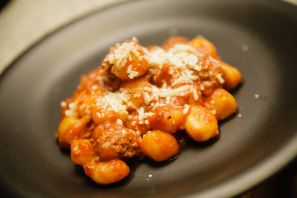 istock Potato gnocchi in tomato sauce and topped with cheese 979729110