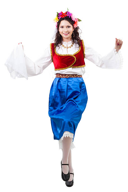 Old traditional women's clothing. A young girl - a woman in Bulgarian folk costume. Silver ornaments, red robe and silver belt. Women's clothing up close.\nBulgarian folklore. Female hands. Sunny day