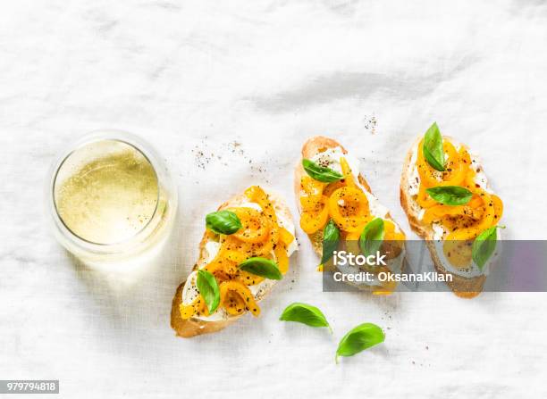 Cream Cheese Roasted Yellow Bell Pepper Basil Bruschetta And White Wine On Light Background Top View Flat Lay Copy Space Stock Photo - Download Image Now