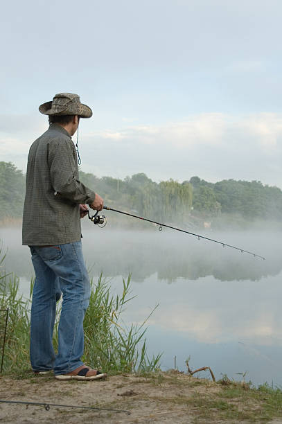 istock fisherman on a morning foggy lake 97979488