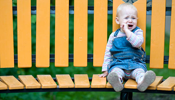 istock Sad Little Girl sitting alone on a bench 97980584