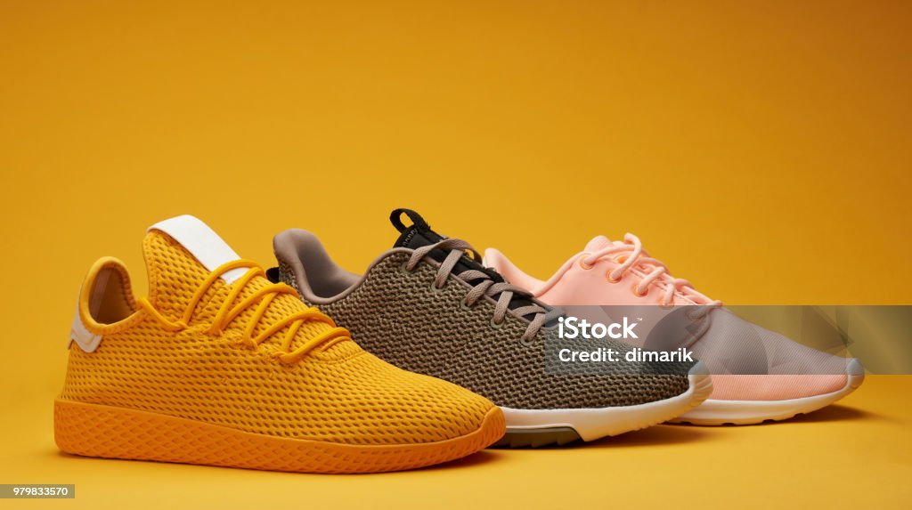 Different color running shoes Different color running shoes on yellow background Shoe Stock Photo