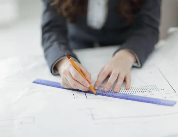 istock closeup.female architect working with blueprints in the office 979843066