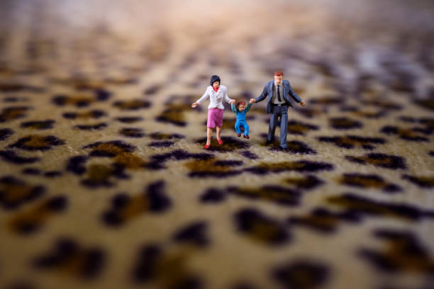 幸せな家族の概念。ミニチュア図の父親、母親と息子の幸せの瞬間であります。ファブリックを印刷虎の上を歩く - figurine small people businessman ストックフォトと画像