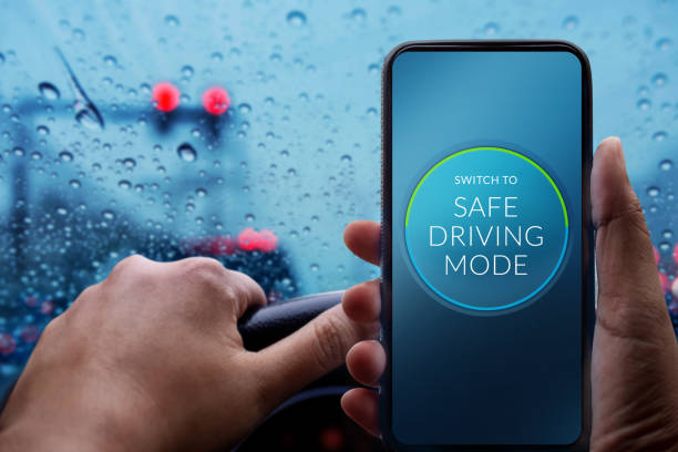 conducir con concepto seguro. controlador de conmutación smartphone a modo de seguridad. día de lluvia y mal tiempo en la carretera con luces borrosas y tráfico jam en la ciudad de - slow jam fotografías e imágenes de stock