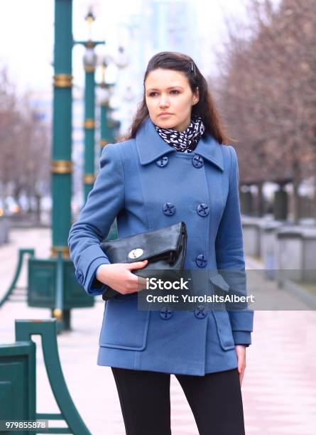 Beautiful Girl In A Purple Coat In The Park With A Clutch In Her Hands Stock  Photo - Download Image Now - iStock