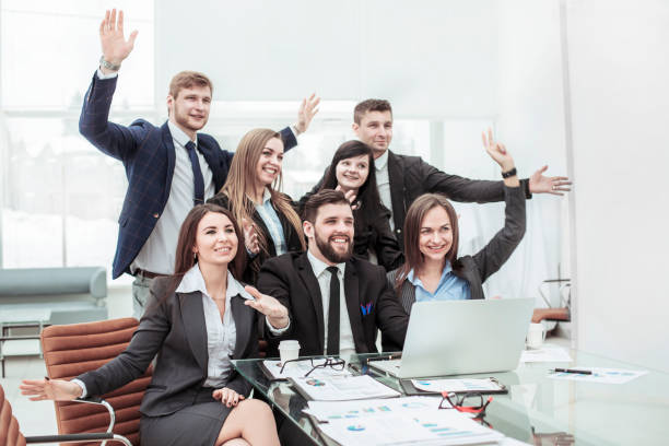 istock business team with their hands up and voting for decision-making near the desktop 979856254