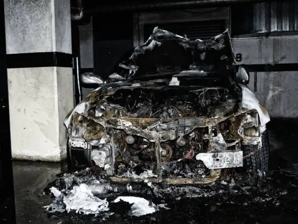burnt out car wreck after fire damage in underground parking garage