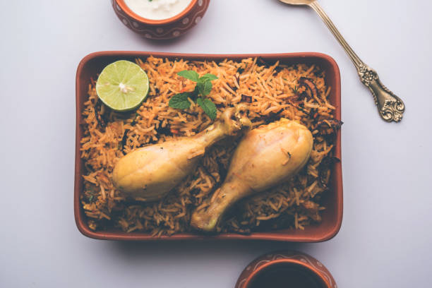 istock Indian Chicken Biryani served in a terracotta bowl with yogurt over white background. selective focus 979873742
