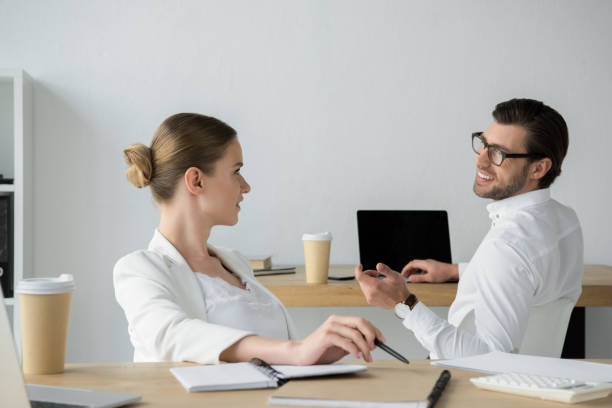 istock happy young business colleagues chatting at workplace in office 979877638