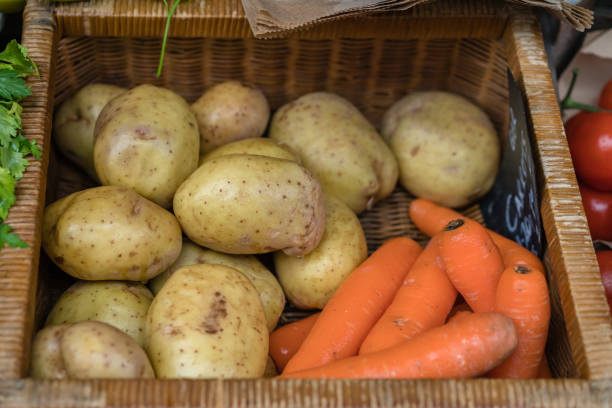 Carrots and potatoes in a wicker basket on a farmers market in Cornwall, england, Uk
