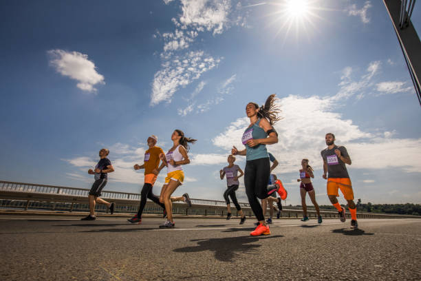 istock Below view of mix-aged athletes running a marathon on the bridge. 979897302