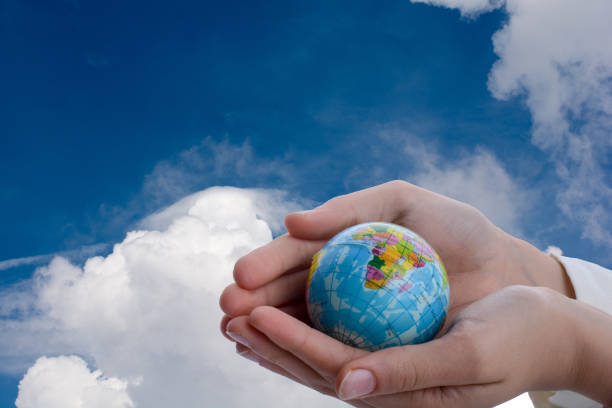 istock Hand holding a little model  globe  in hand 979897424
