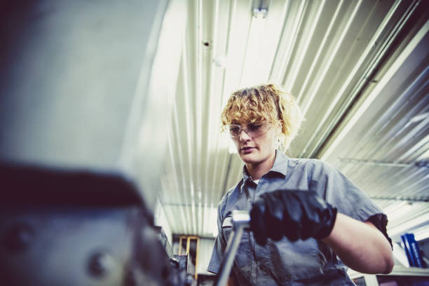 meccanico femminile che lavora su un macchinario pesante - minimum wage foto e immagini stock