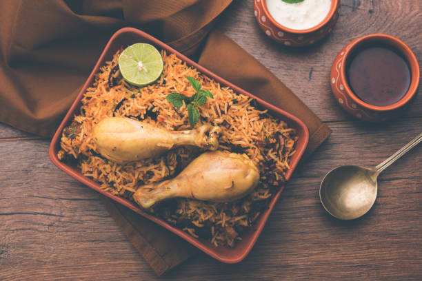 istock Indian Chicken Biryani served in a terracotta bowl with yogurt over white background. selective focus 979900366