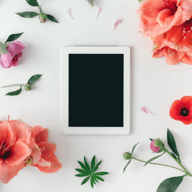 istock Flat lay tablet with blank screen with flowers 979901178
