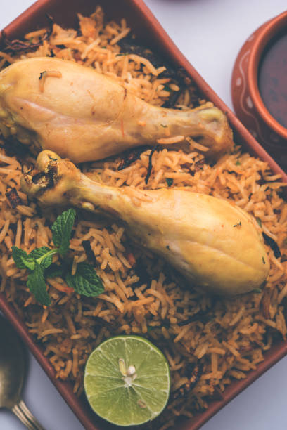 istock Indian Chicken Biryani served in a terracotta bowl with yogurt over white background. selective focus 979902616