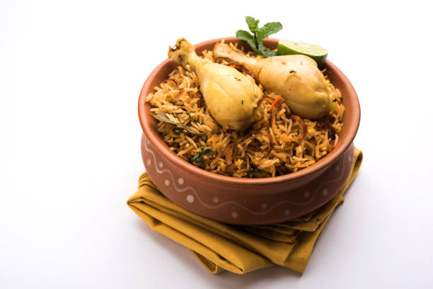 Indian Chicken Biryani served in a terracotta bowl with yogurt over white background. selective focus Indian Chicken Biryani served in a terracotta bowl with yogurt over white background. selective focus masala stock pictures, royalty-free photos & images