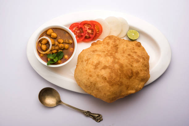 Chole Bhature or Chick pea curry and Fried  Puri served in terracotta crockery over white background. selective focus Chole Bhature or Chick pea curry and Fried  Puri served in terracotta crockery over white background. selective focus Cardamom stock pictures, royalty-free photos & images