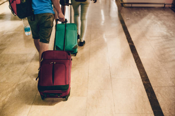 istock Young People Dragging Suitcases at Airport 979916440