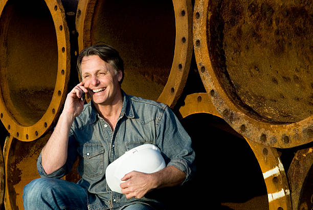 happy smiling construction worker on cellphone. stock photo