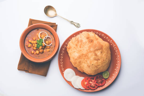 Chole Bhature or Chick pea curry and Fried  Puri served in terracotta crockery over white background. selective focus Chole Bhature or Chick pea curry and Fried  Puri served in terracotta crockery over white background. selective focus Cardamom stock pictures, royalty-free photos & images