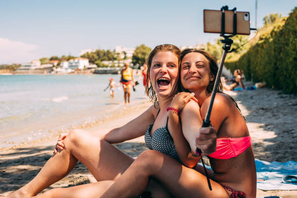 istock Young Lesbian Couple Taking a Selfie on Beach 979926236