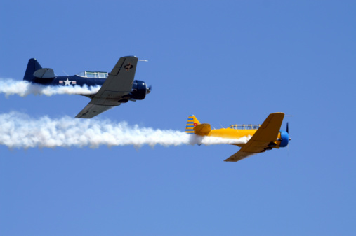 Two antique aircraft in flight.