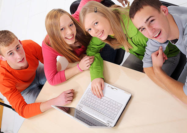 adolescents avec un ordinateur portable regarder vers le haut. - studygroup photos et images de collection