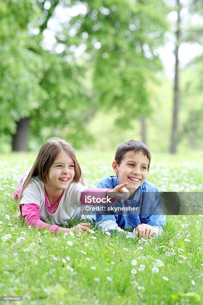SZCZĘŚLIWE dzieci leżąc na trawie, z palcami. - Zbiór zdjęć royalty-free (Beztroski)