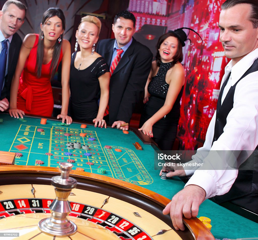 Croupier es spinning la ruleta, mientras s'espera un gamblers - Foto de stock de Entusiasmo libre de derechos