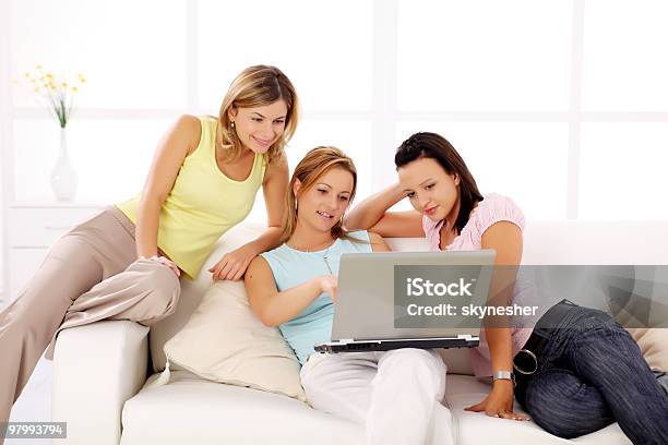 Tre Fidanzate Seduto Sul Divano Con Il Computer Portatile - Fotografie stock e altre immagini di Adulto