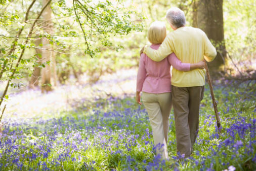 elderly couple in love walking in the garden while looking at each other