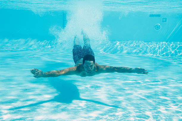 hombre en la piscina bajo el agua - moviendo hacia abajo fotografías e imágenes de stock