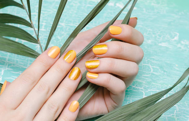 istock Female hands with orange nail design 979944912