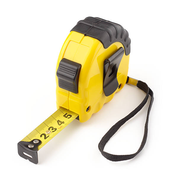 A yellow and black tape measure opened to five inches stock photo