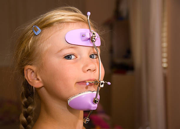 chica con orthodontics cabezal de engranajes - accesorio de cabeza fotografías e imágenes de stock