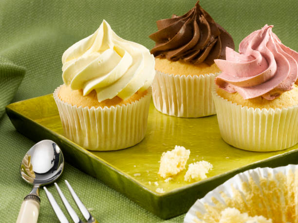 Three cup cakes on a green plate stock photo