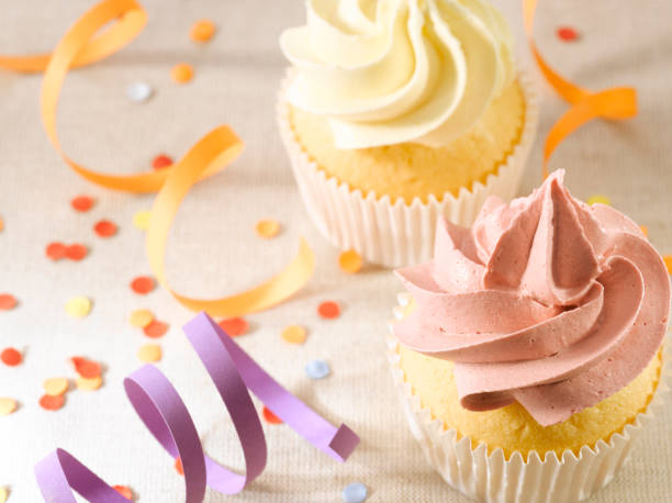 Closeup of cup cakes surrounded by confetti stock photo