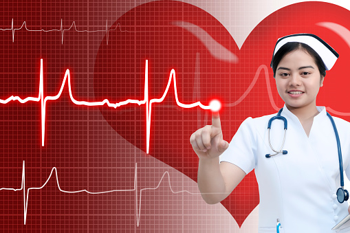 Young doctor or nurse pointing to cardiogram with red heart on the background