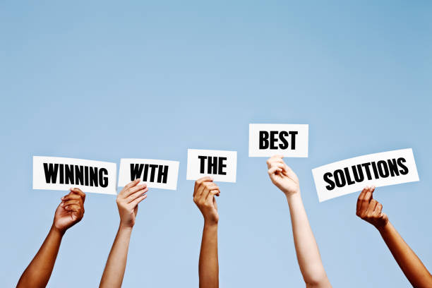 istock 'Winning with the best solutions' say hand-held signs 979982626