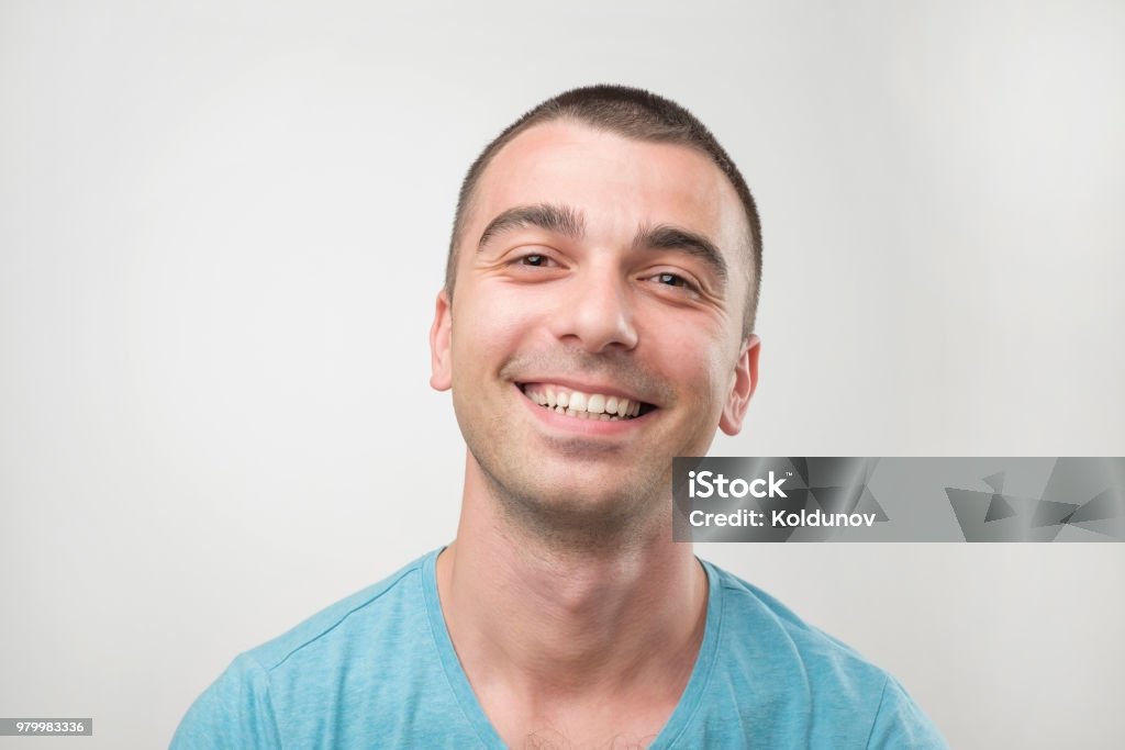 Closeup ortrait of smiling man in blue t-shirt. Closeup ortrait of smiling man in blue t-shirt. Positive facial emotion Adult Stock Photo