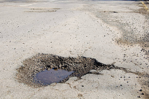 istock Severe pothole damage in a main road 97998474