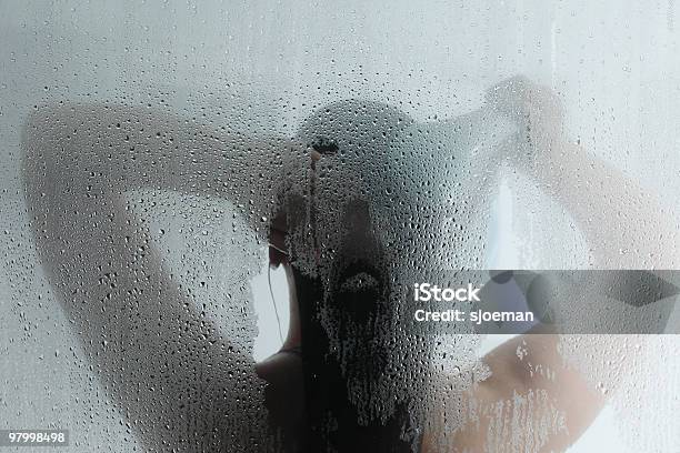 Silhouette Of Woman Taking Shower Behind Steamy Door Stock Photo - Download Image Now