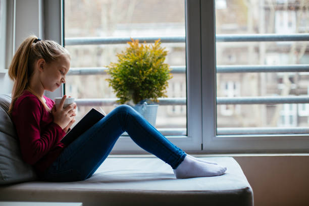 istock Blond girl reading a book 979999864