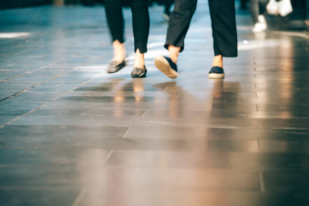 istock Blurred motion of people legs walking on pavement with copy space 980007298