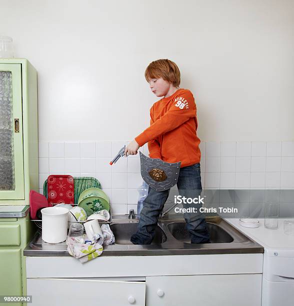 Boy Standing In Sink Shooting The Dishes Stock Photo - Download Image Now - Child, Sink, Toy Gun